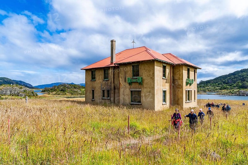 Hikers in front of the museum at a historic Yaghan aboriginal settlement, Wulaia Bay, Navarino Island on the Murray Channel, Patagonia, Chile, South America