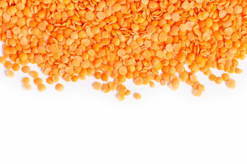 Texture of red lentils isolated on white background. Top view