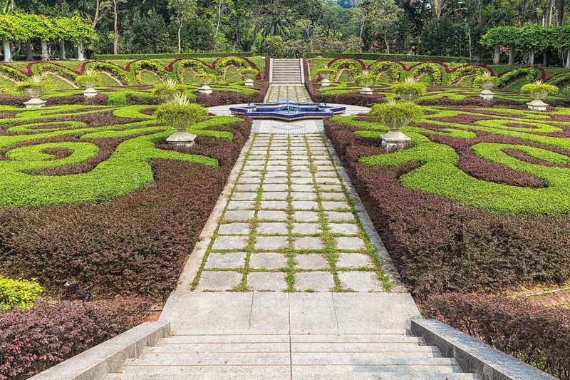 Part of a regular garden with cropped hedges and fountain