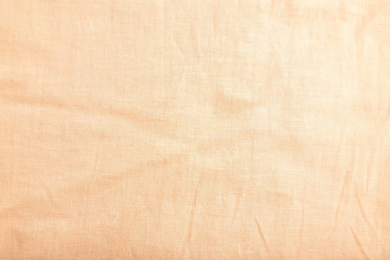 Fragment of smooth orange linen tissue. Top view, flat lay, natural textile background and texture