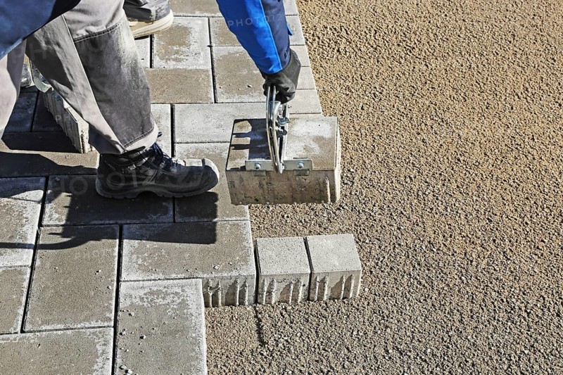 Workers lay paving stones