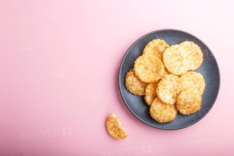 Traditional japanese rice chips cookies with honey and soy sauce on a pastel pink background. Top view, flat lay, copy space
