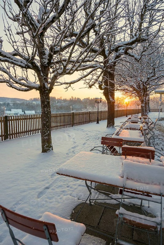Snow-covered beer garden in winter, sunset, Andechs Monastery, Fuenfseenland, Pfaffenwinkel, Upper Bavaria, Bavaria, Germany, Europe