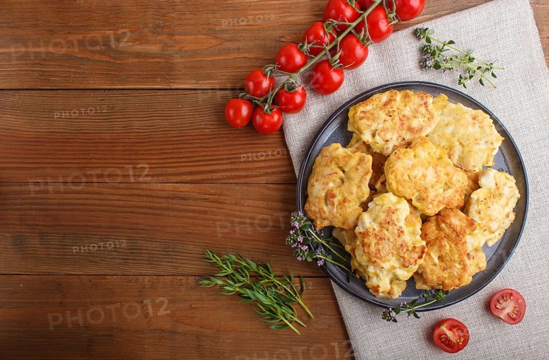 Minced chicken cutlets with herbs on brown wooden background. top view, flat lay, copy space