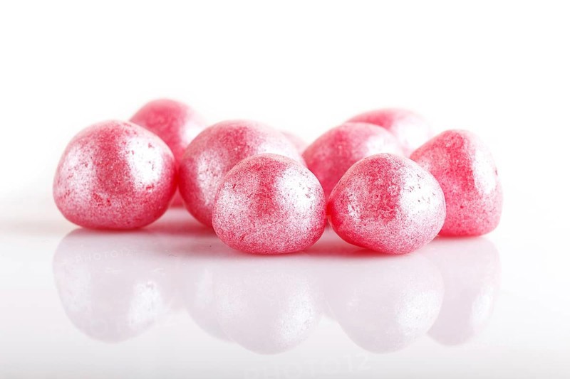 Heap of pink hard sugar candies isolated on white background