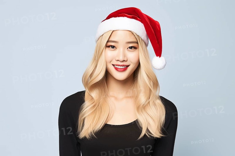 Young Asian woman with long blond hair and red Christmas Santa hat. KI generiert, generiert AI generated