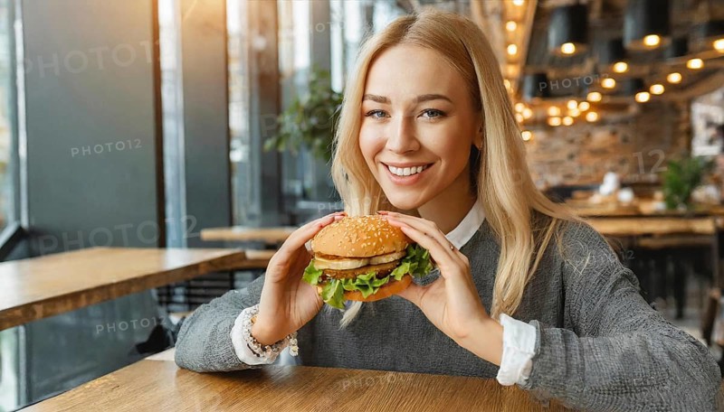 AI generated, human, humans, person, persons, woman, woman, 25, years, sits in restaurant, a person, seasons, eats, eating, burger, hamburger, snack bar
