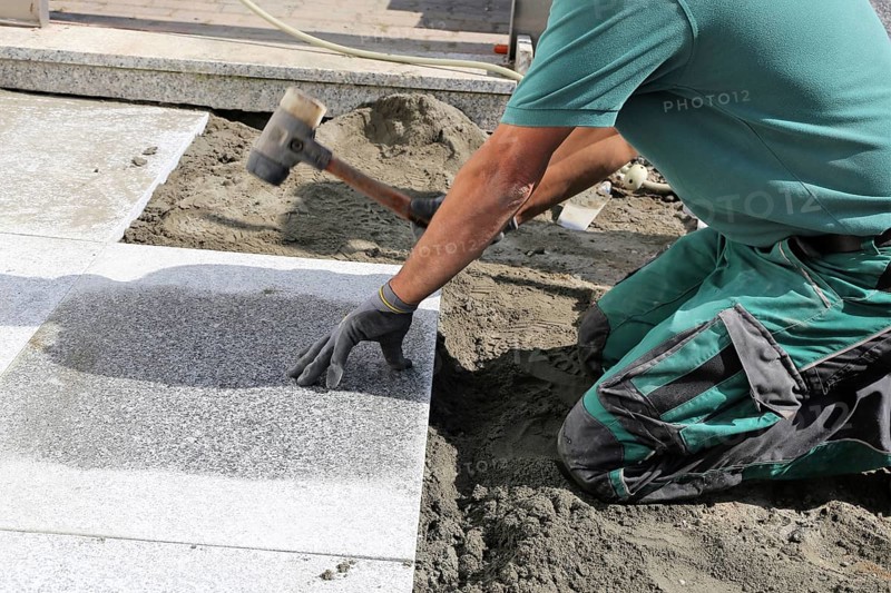 Worker lays paving stones