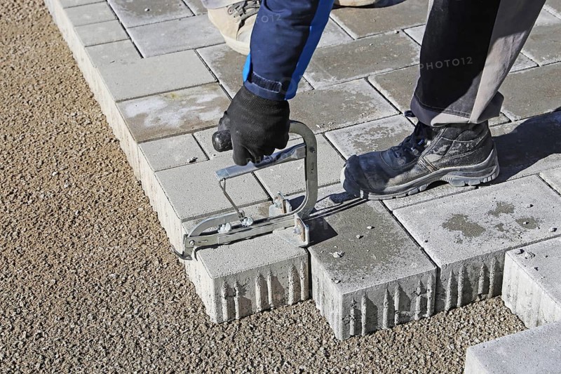 Workers lay paving stones