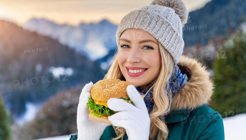 AI generated, human, humans, person, persons, woman, woman, 25, years, one, outdoor, ice, snow, winter, seasons, eats, eating, burger, hamburger, cap, bobble hat, gloves, winter jacket, cold, coldness