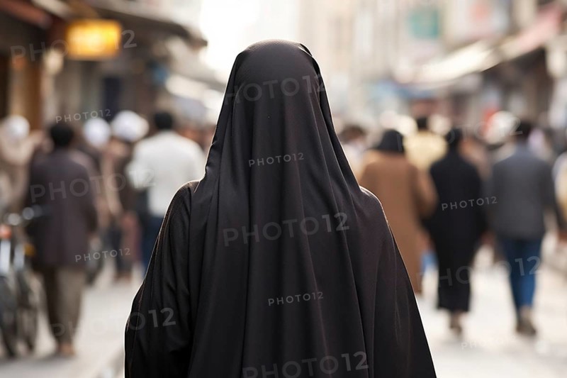 Back view of woman covered with black Muslim Niqab face veil in city street with people. KI generiert, generiert AI generated