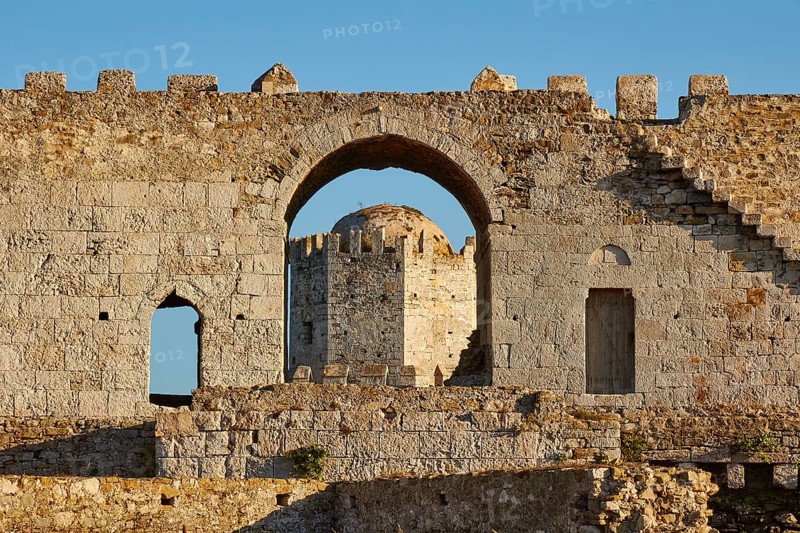 Part of an old castle wall with arches and window openings under a clear blue sky, sea fortress Methoni, Peloponnese, Greece, Europe