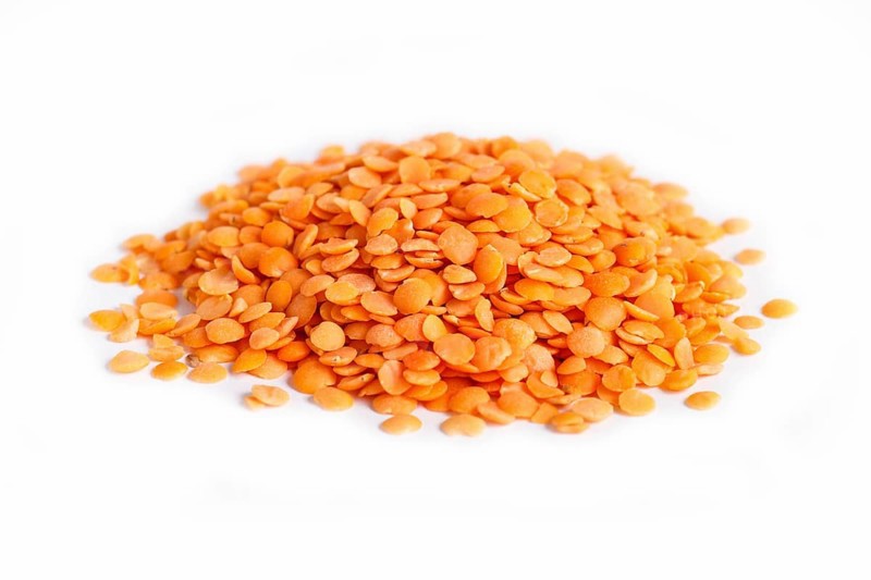 Pile of red lentils isolated on white background. Closeup