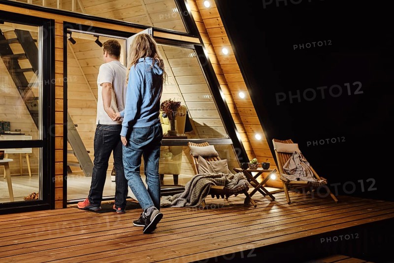 A couple returns to tiny log cabin late at night after a walk outdoors