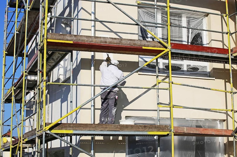 Painter painting the facade of a new residential building (Mutterstadt development area, Rhineland-Palatinate)