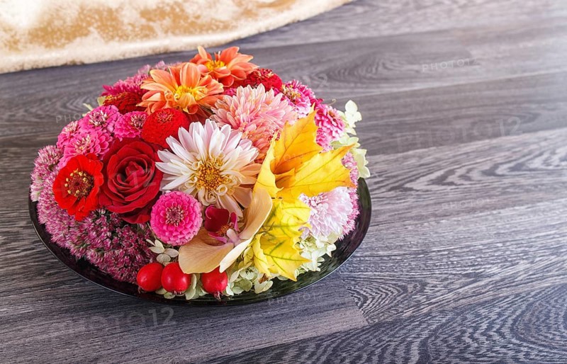 Floral arrangement of autumn flowers on a plate. dahlia, zinnia, rose, orchid, maple leaves. copy space