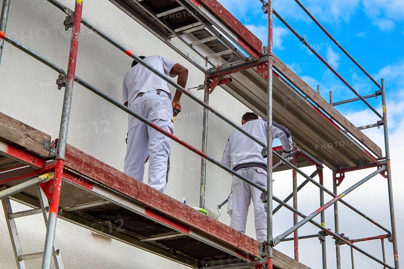 Painter painting the facade of a new residential building