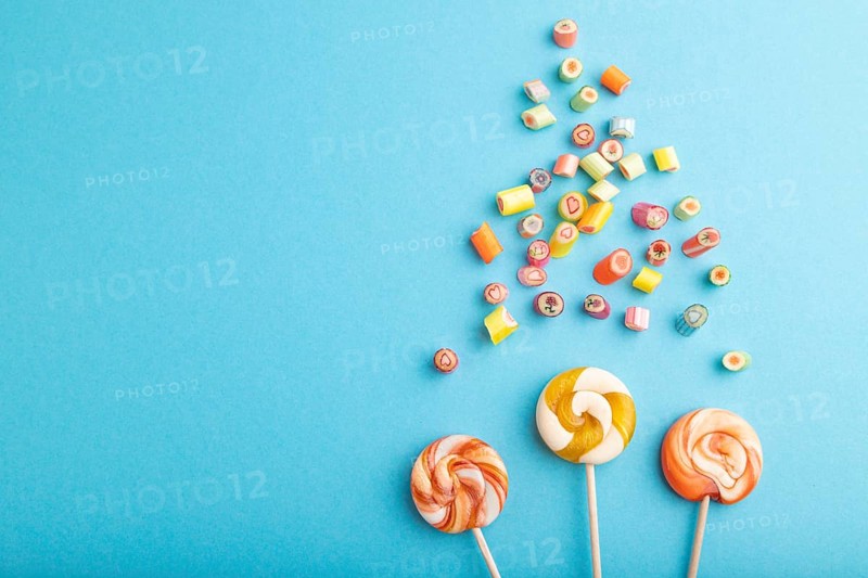Various caramel candies on blue pastel background. copy space, top view, flat lay