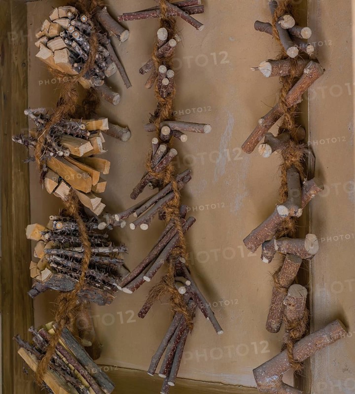 Pieces of wood used to make oriental medicine tied together with hemp rope and hanging on wall in South Korea