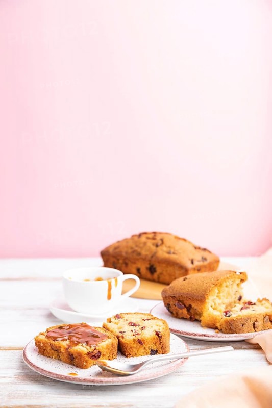 Homemade cake with raisins, almonds, soft caramel on a white and pink background. Side view, selective focus, copy space