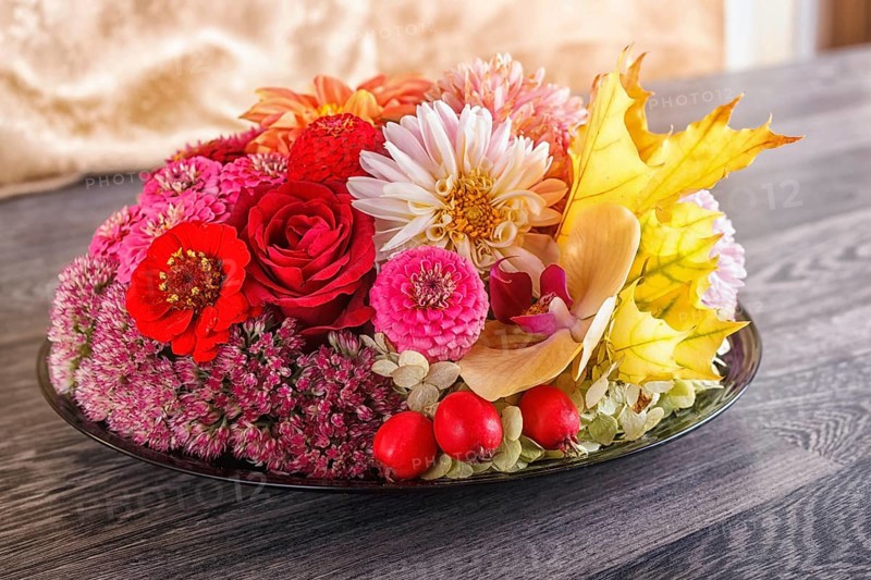 Floral arrangement of autumn flowers on a plate. dahlia, zinnia, rose, orchid, maple leaves