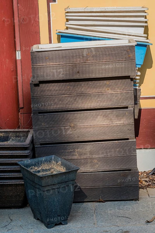 Disused wooden and plastic planter boxes outdoors against wall of building in South Korea