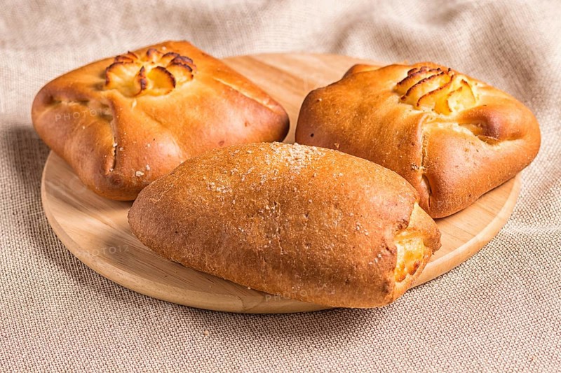 Sweet buns on a wooden board and linen tablecloth