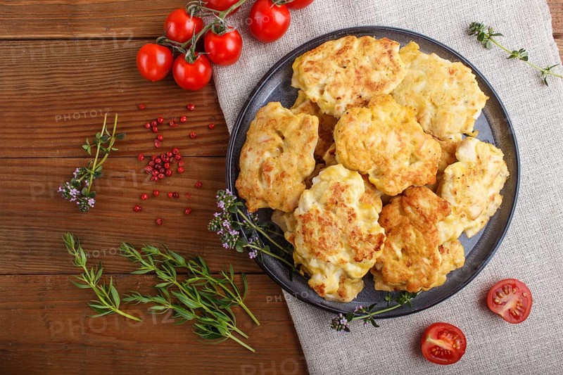 Minced chicken cutlets with herbs on brown wooden background. top view, flat lay, close up