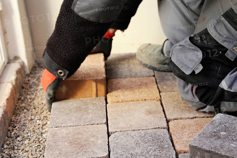 Worker lays paving stones