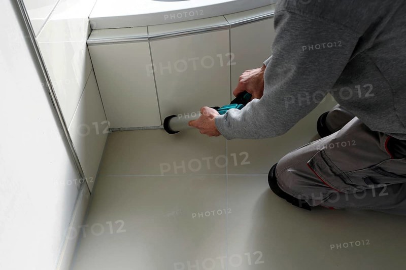 Grouting work. Tiler grouting in a new bathroom