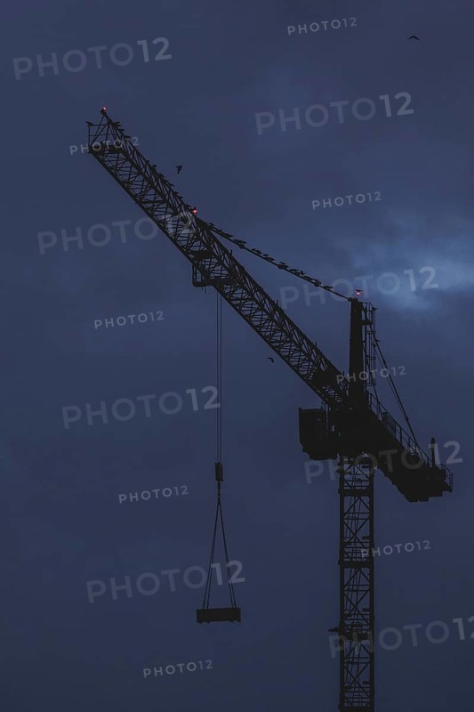 A crane works at blue hour in Berlin, 20/02/2024