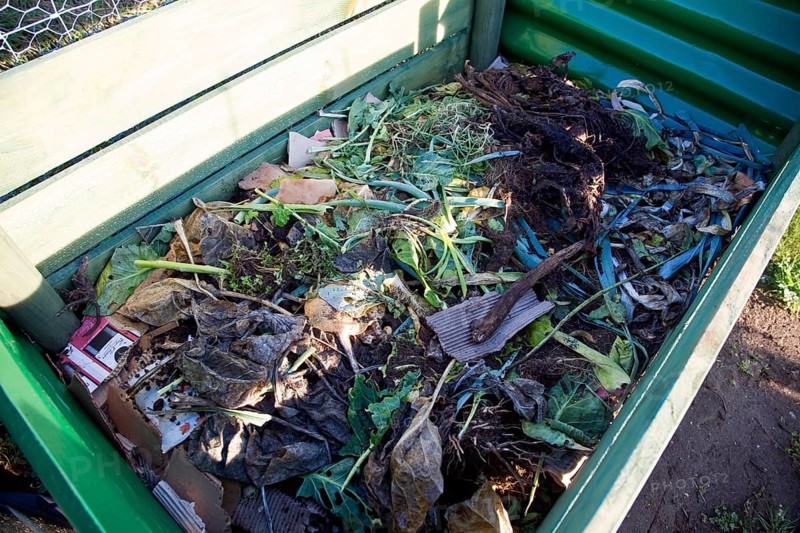 Organic vegetable matter decomposing in compost bin