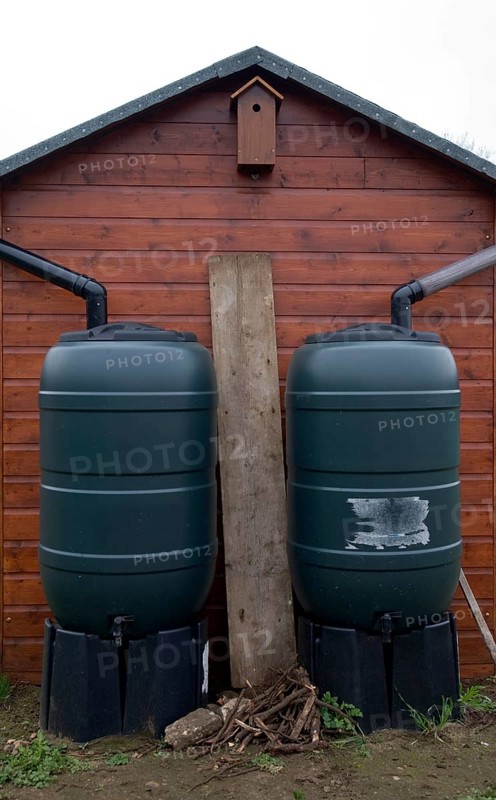 Two water butts illustrating concept of watershed dividing drainage basins on roof