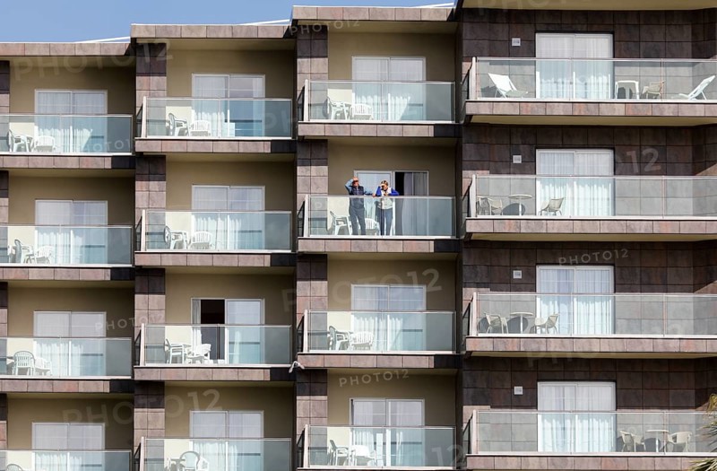 An elderly couple looks out from a balcony of an apartment complex in Torremolinos, Costa del Sol, 13/02/2019