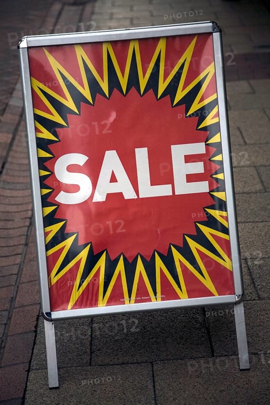 Close up of street shop Sale poster standing on pavement