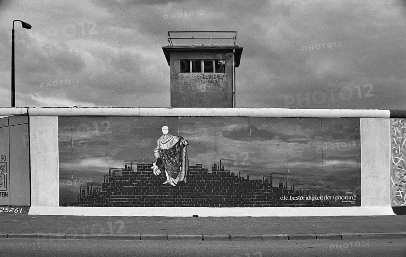 Painting Die Bestaendigkeit der Ignoranz by Karsten Wenzel, behind it a former watchtower of the GDR border troops, summer 1990, East Side Gallery, Muehlenstrasse, Friedrichshain district, Berlin, Germany, Europe