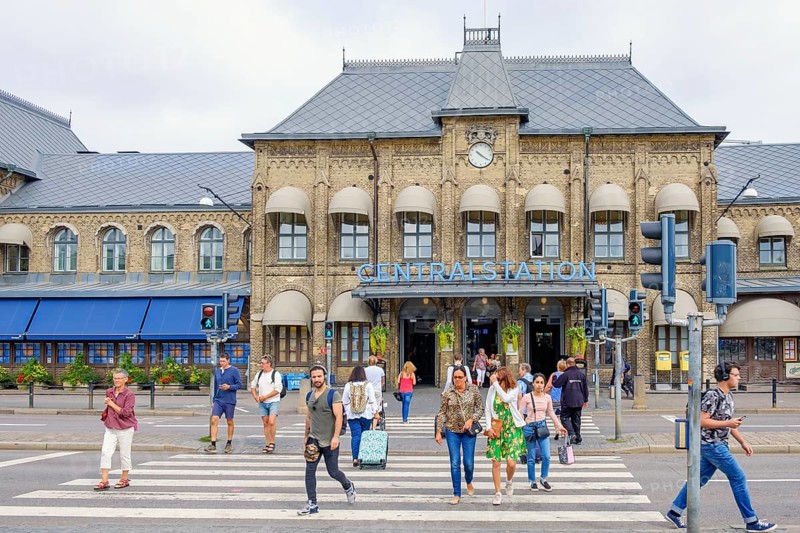 Railway station in Gothenburg with people crossing a city street at the pedestrian crossing, Gothenburg, Sweden, Europe