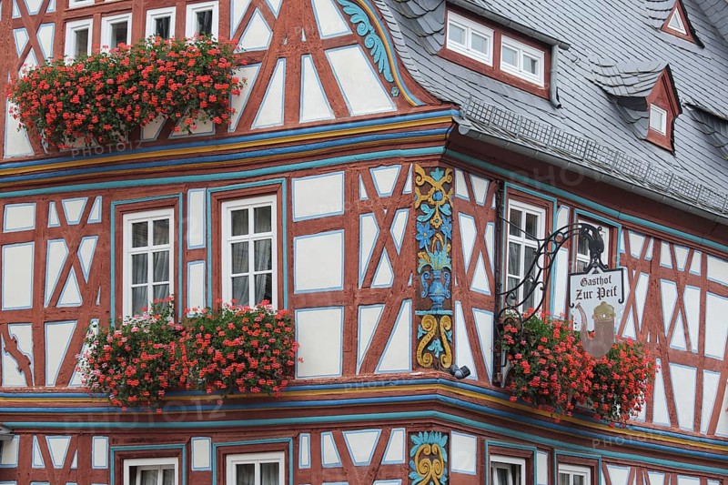 Half-timbered house and Gasthof zur Pfeif with ornaments, floral decoration and nose sign, Koenig-Adolf-Platz, Idstein, Taunus, Hesse, Germany, Europe