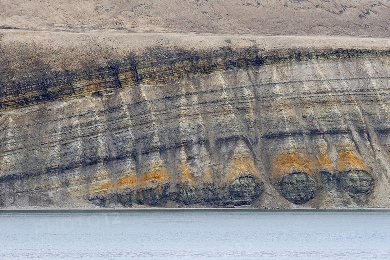 Sea cliff showing limestone and sandstone strata from the Permian period along the Hinlopen Strait, Hinlopenstretet, Spitsbergen, Svalbard, Norway, Europe