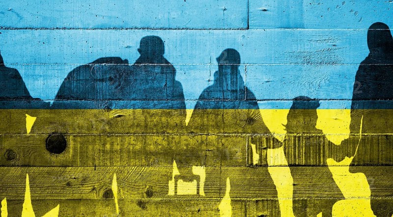 Ukrainian flag painted on a concrete wall with Ukrainian refugees