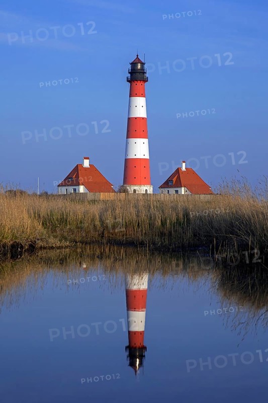 Lighthouse Westerheversand reflected in pond at Westerhever at dusk, Peninsula of Eiderstedt, Wadden Sea National Park, North Frisia, Germany, Europe