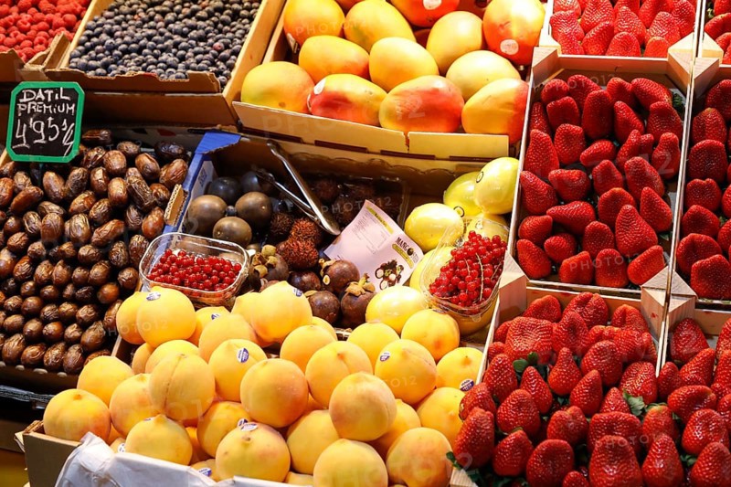 Fresh strawberries, mangoes, dates, peaches, blueberries and redcurrants at the fruit and vegetable market in Malaga, 12/02/2019