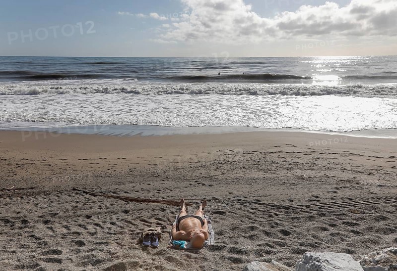A man sunbathes on the deserted beach of Torremolinos, Spain, Costa del Sol, 13/02/2019, Europe