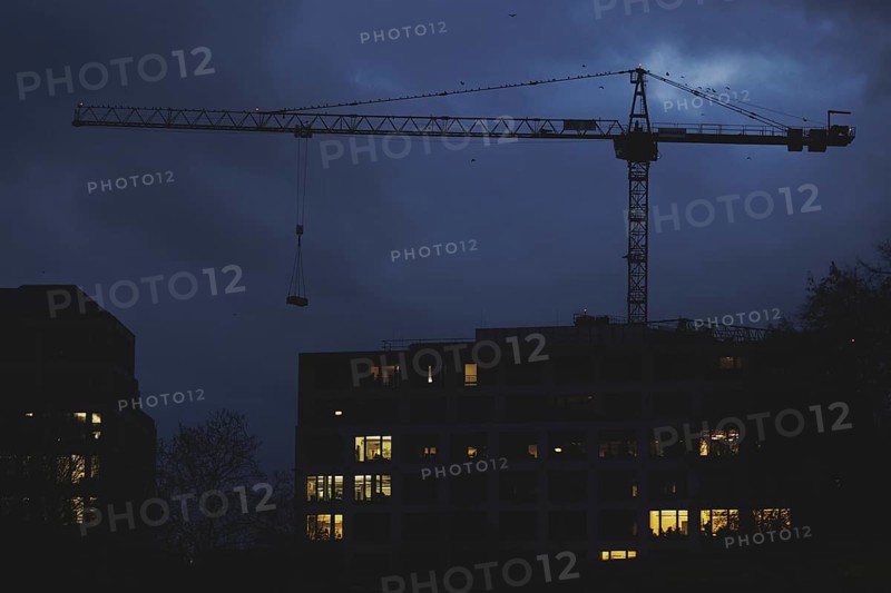 A crane works at blue hour in Berlin, 20/02/2024