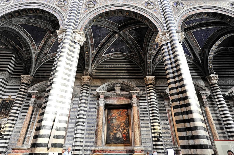 The nave of the cathedral with its black and white striped marble columns, cross and round arches, Siena, Tuscany, Italy, Europe