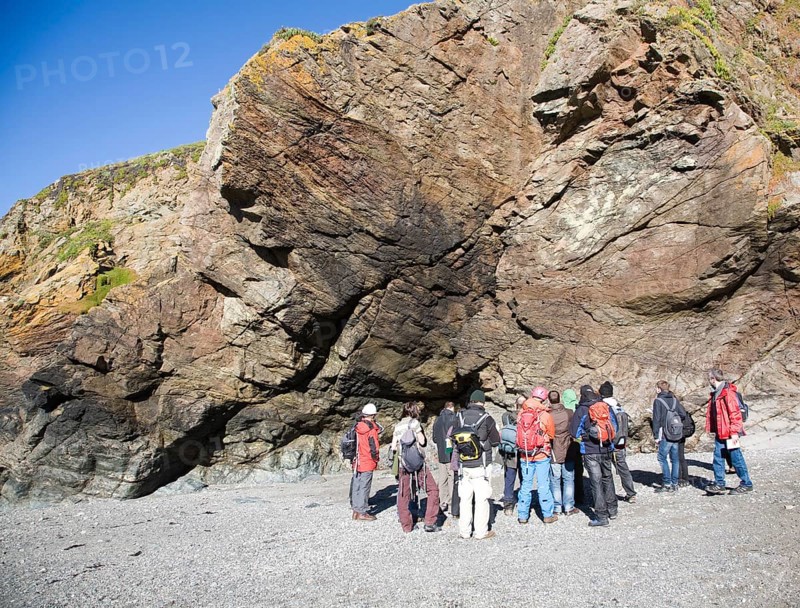 Student group of geologists on a fieldtrip at Polpeor Cove, Lizard Point, Cornwall, England, United Kingdom, Europe