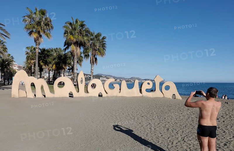 A man takes a photo of a large Malagueta logo. Malagueta is the name of the beach in Malaga, on the Costa del Sol, 11/02/2019