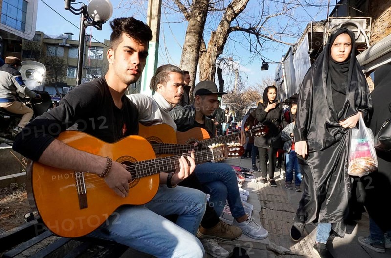 Young Iranian street musicians with guitars in Arak, Iran, woman with chador on 16 March 2019. After the withdrawal of the USA from the international nuclear agreement, the country is again imposing sanctions against Iran, Asia