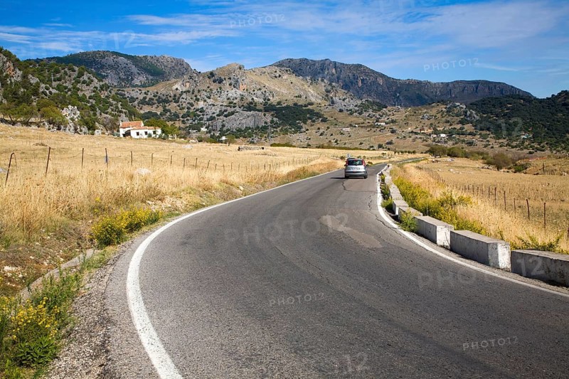 Vehicle driving around corner in rural road in Sierra de Grazalema natural park, Cadiz province, Spain, Europe