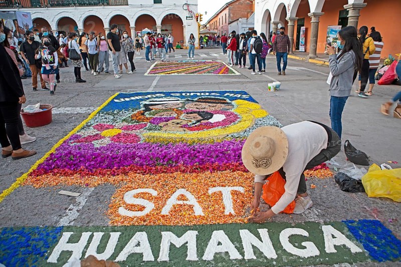 Peruvian woman making a floor painting in the Plaza de Armas, spectators watching, Ayacucho, Huamanga province, Peru, South America